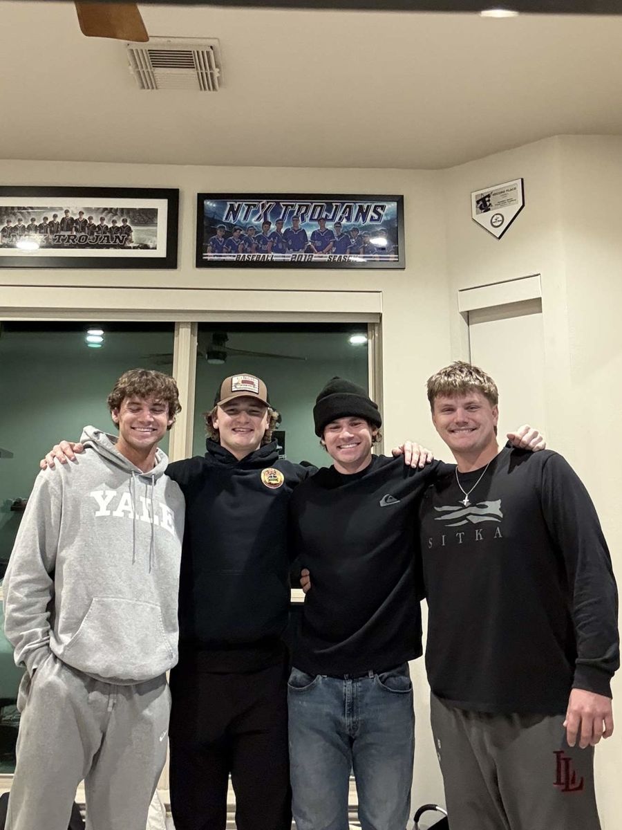 Jack and three friends in dark hoodies, arms around each other